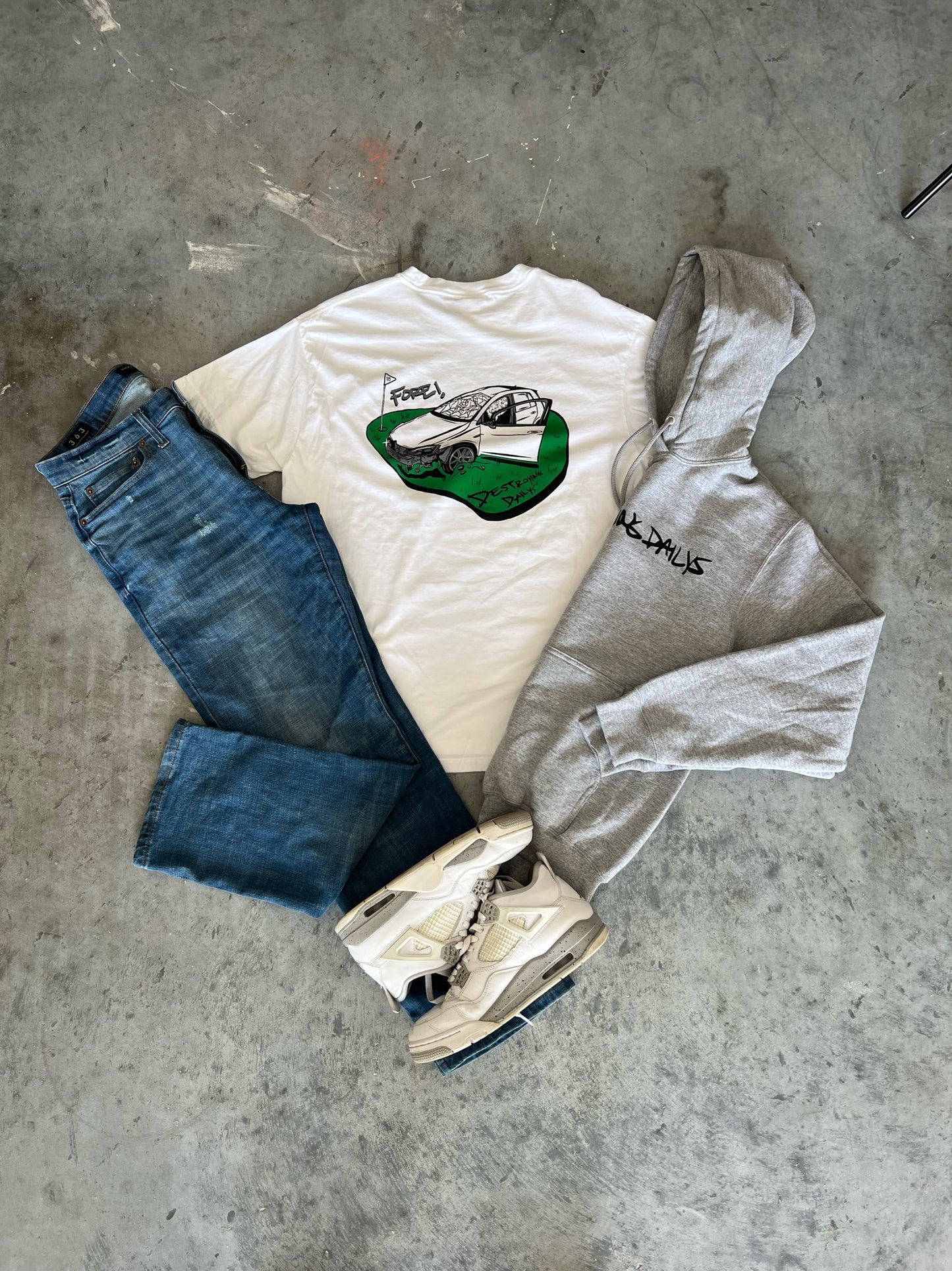 White 100% cotton t-shirt featuring a hand-drawn crashed Golf GTI on a golf course with the text "Fore! Destroying Dailys," perfect for car enthusiasts styled with jordans and streetwear clothing 