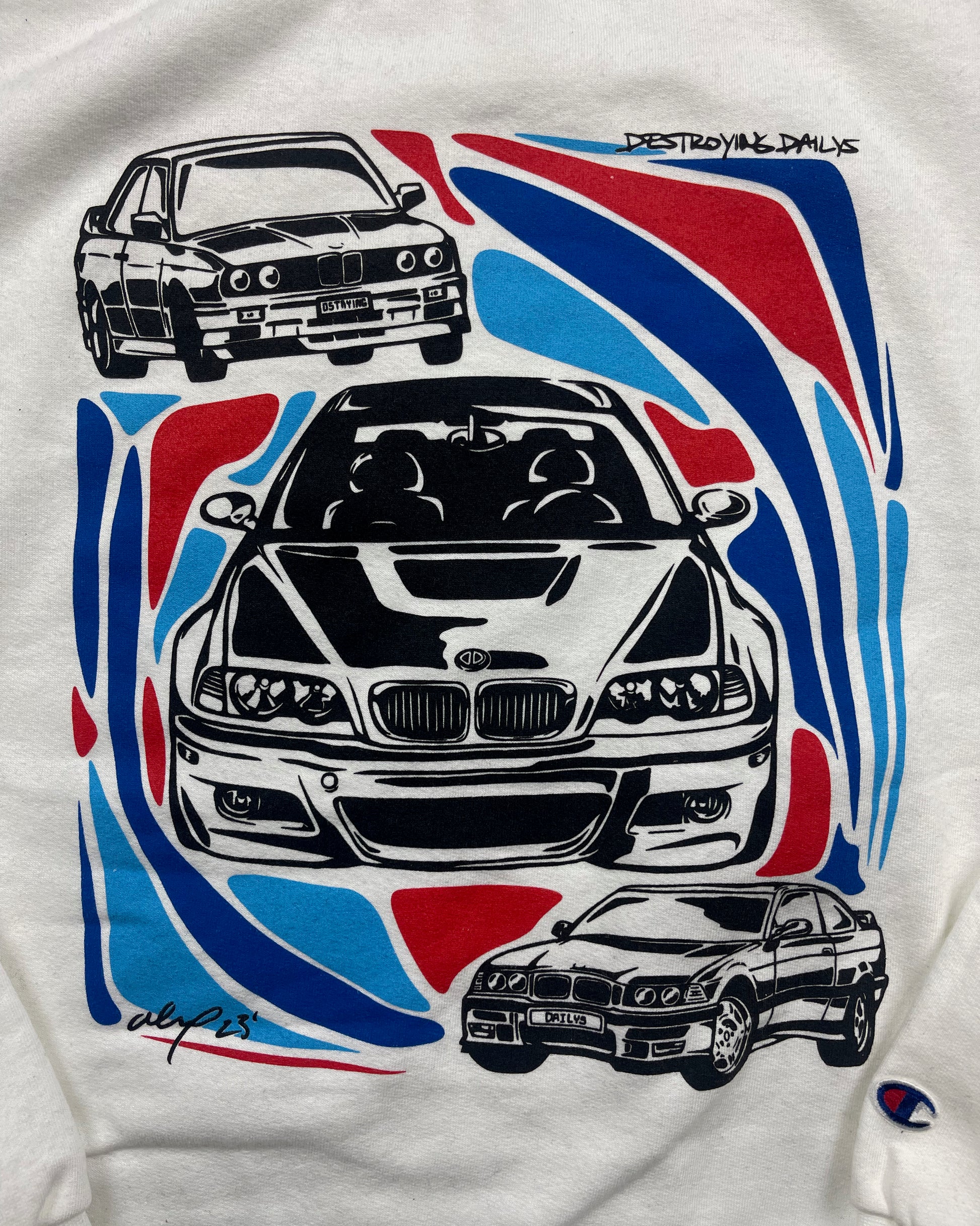 close up view of White crewneck sweatshirt made of 50/50 cotton and polyester blend featuring hand-drawn BMW E30, E36, and E46 M3s with red, blue, and black accents, perfect for car enthusiasts. Bmw sweatshirt for car guys