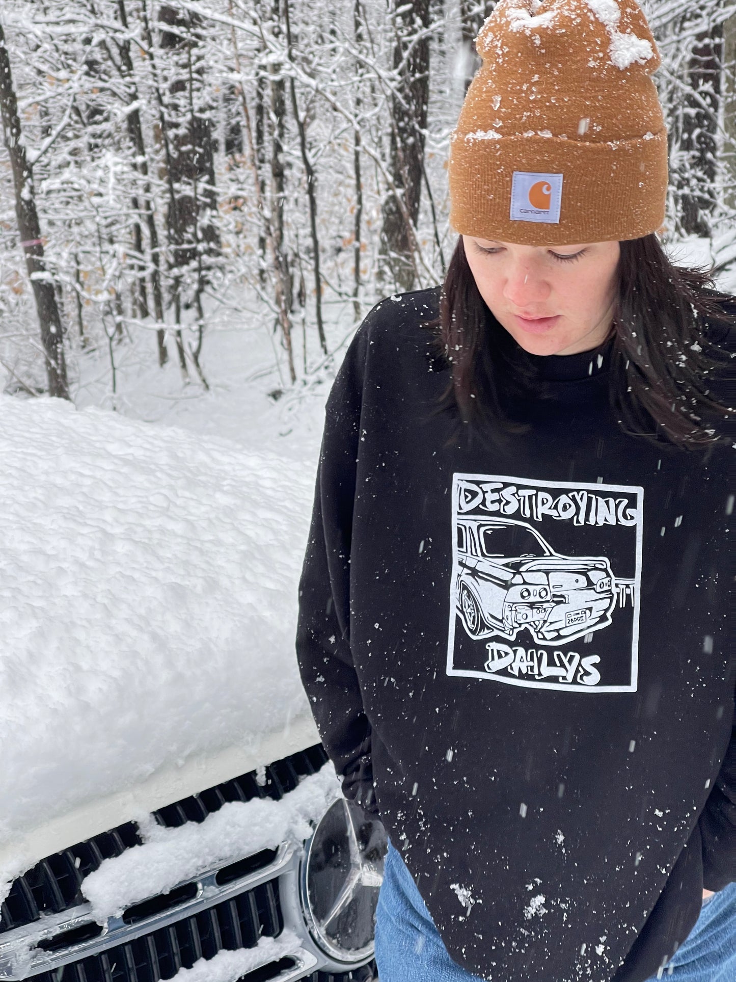 Female model wearing Black crewneck sweatshirt made of 50/50 cotton and polyester blend featuring a hand-drawn JDM Skyline R32 with the text "Destroying Dailys," perfect for car enthusiasts. JDM sweatshirt for car guys, Nissan Skyline sweatshirt