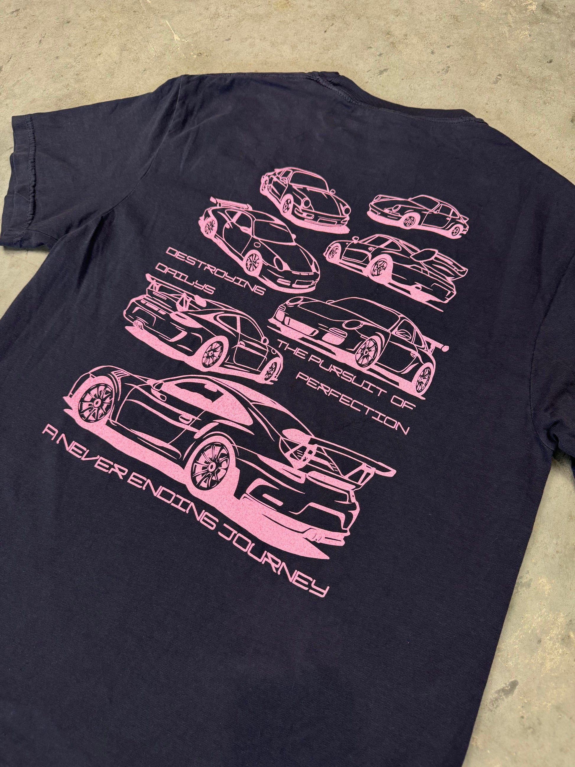 detailed view of Navy blue 100% cotton t-shirt featuring hand-drawn Porsche 911 GT3 RS designs with the text "Destroying Dailys The Pursuit of Perfection A Never Ending Journey," perfect for car enthusiasts. Porsche Tee for Porsche Fans. Porsche 911 GT3 Tee