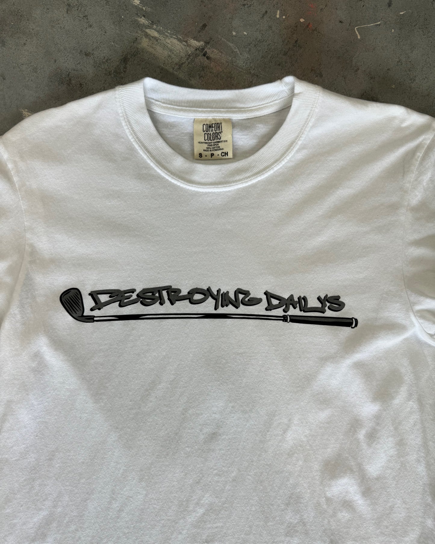 close up front view of White 100% cotton t-shirt featuring a hand-drawn crashed Golf GTI on a golf course with the text "Fore! Destroying Dailys," perfect for car enthusiasts.