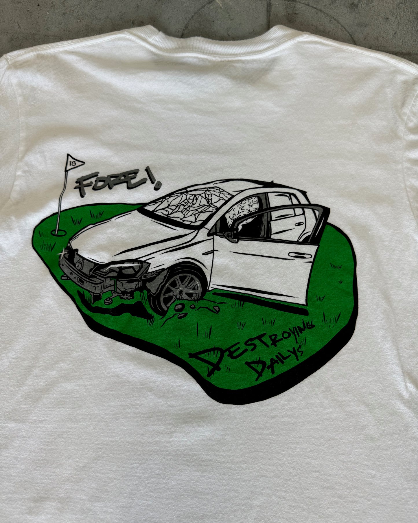 close up of back of White 100% cotton t-shirt featuring a hand-drawn crashed Golf GTI on a golf course with the text "Fore! Destroying Dailys," perfect for car enthusiasts.