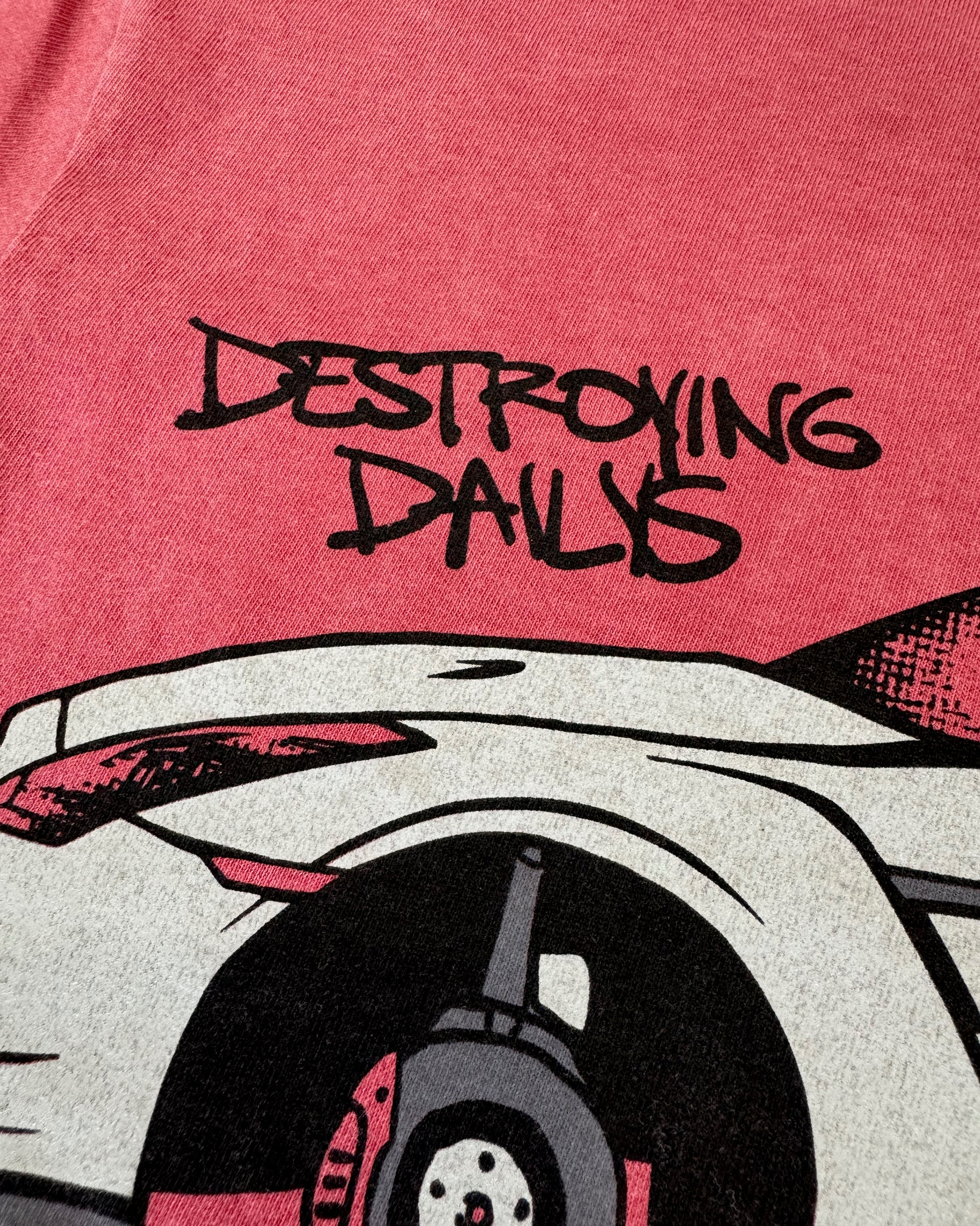 Red 100% cotton t-shirt featuring a hand-drawn Nissan GTR on bricks with the text "Destroying Dailys Bricked Up!" perfect for JDM enthusiasts. Funny Tee for Car guys close up detailed photo