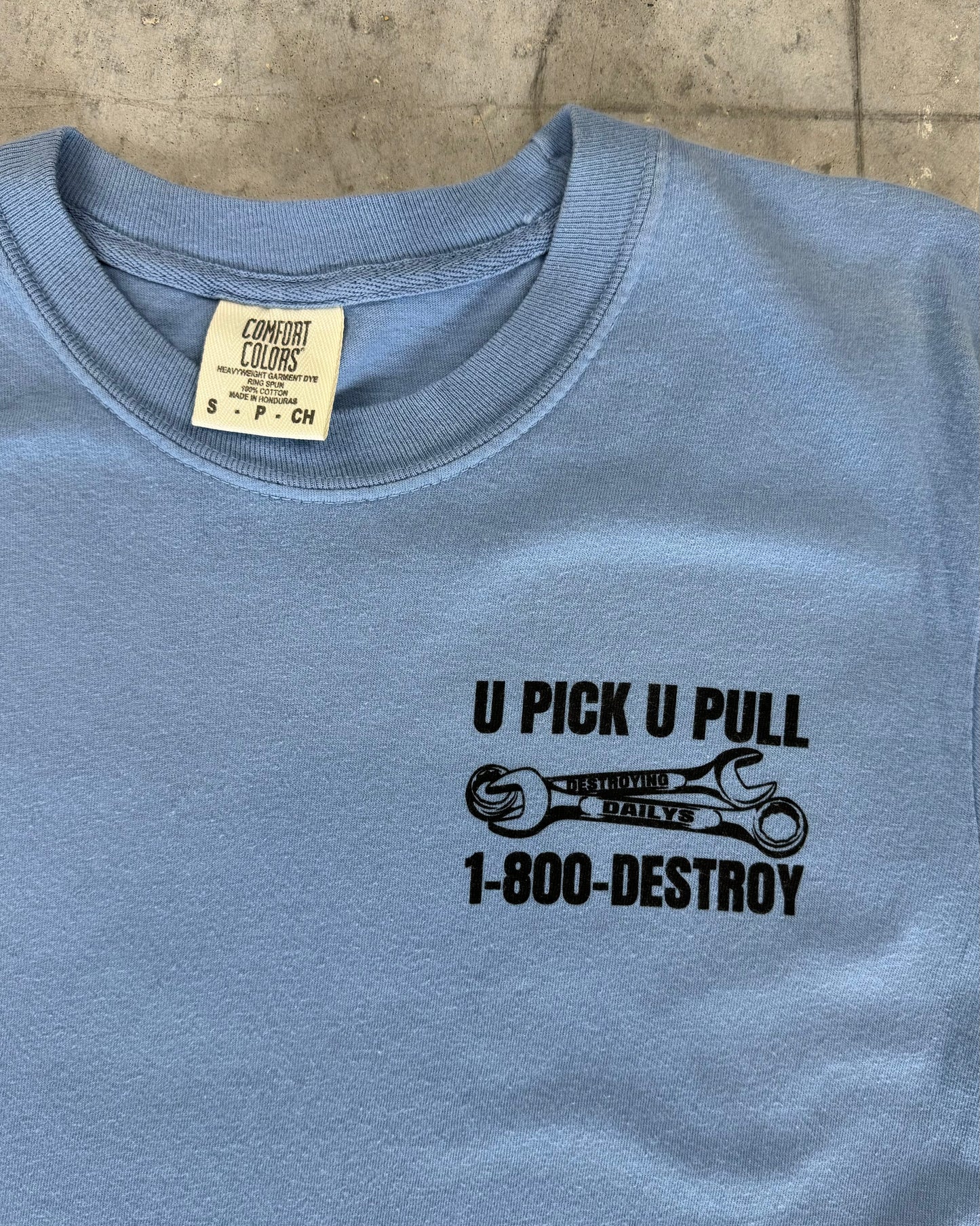 Light blue 100% cotton t-shirt with a small front graphic reading "U Pick U Pull 1-800-DESTROY," perfect for JDM car enthusiasts. Front of the shirt, Close up detailed photo