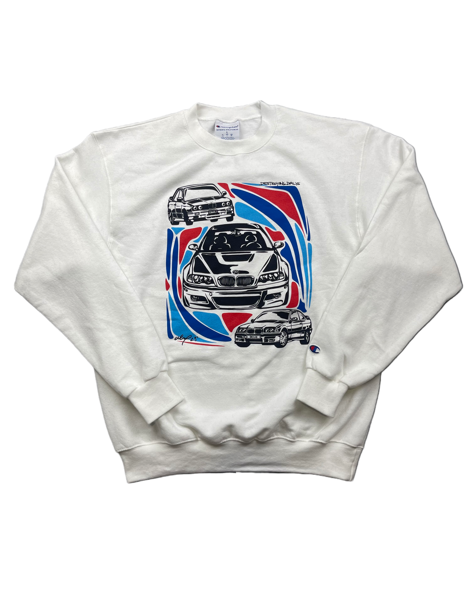 White crewneck sweatshirt made of 50/50 cotton and polyester blend featuring hand-drawn BMW E30, E36, and E46 M3s with red, blue, and black accents, perfect for car enthusiasts. Bmw sweatshirt for car guys