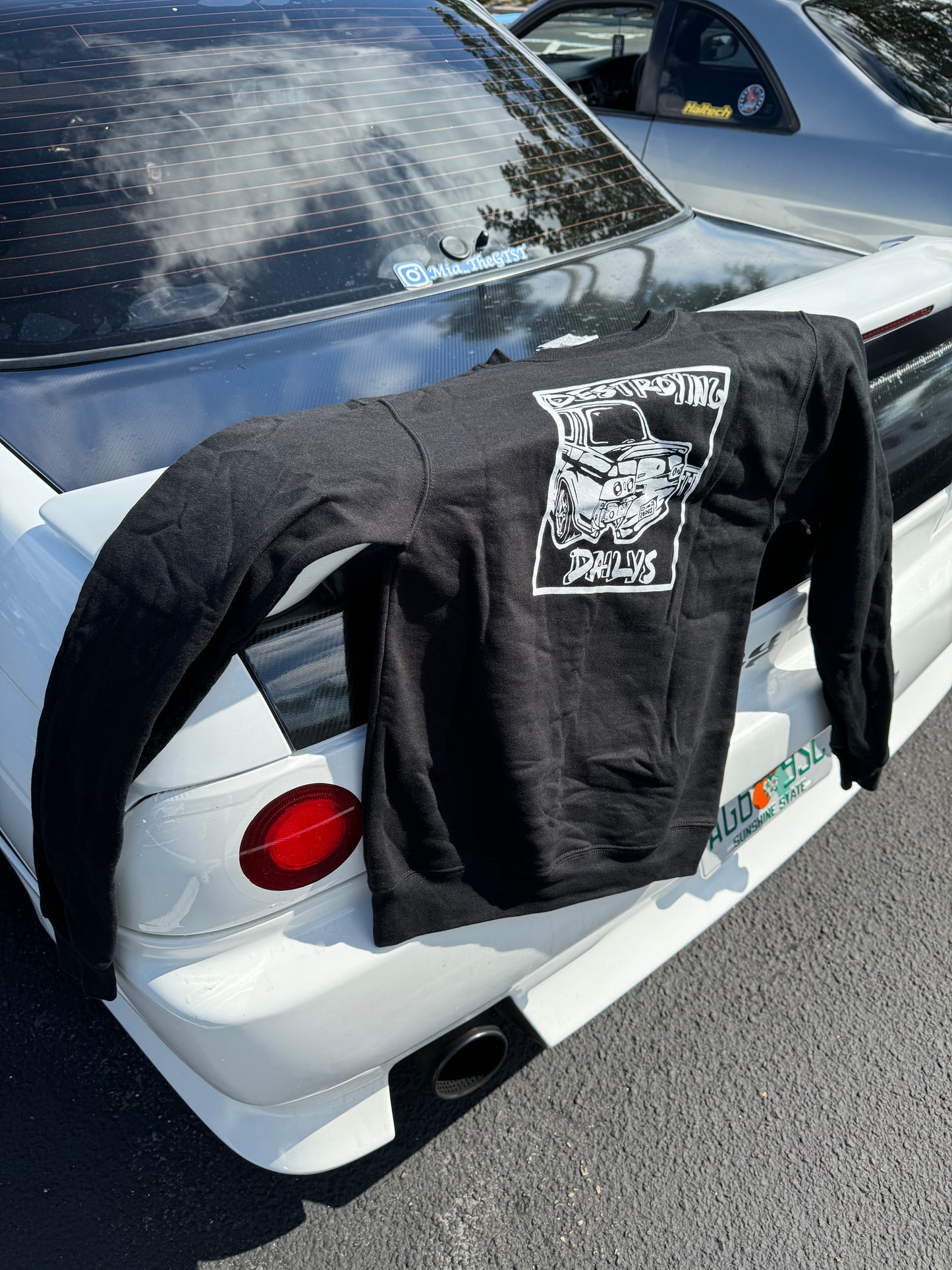  Black crewneck sweatshirt made of 50/50 cotton and polyester blend featuring a hand-drawn JDM Skyline R32 with the text "Destroying Dailys," perfect for car enthusiasts. JDM sweatshirt for car guys, Nissan Skyline sweatshirt on a nissan skyline taillight