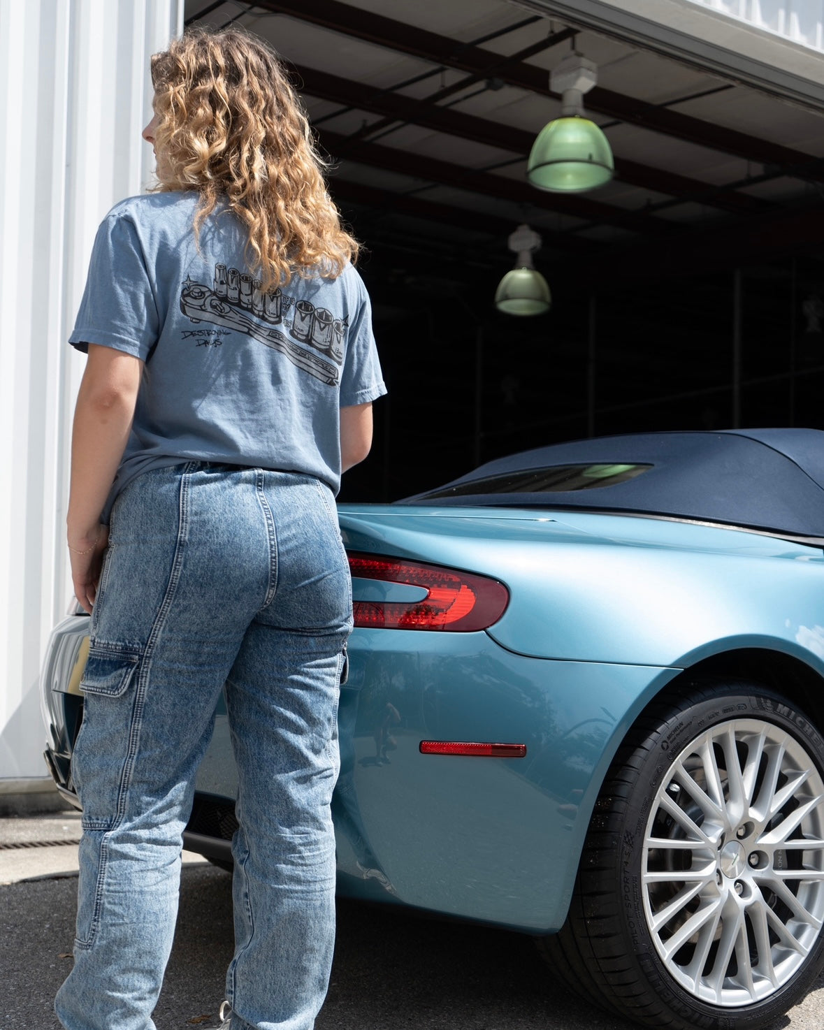 Car mechanic t shirt with a missing 10 Millimeter socket and a socket wrench. T shirt for car guys and car enthusiasts. 100% cotton tee shirt for car guys and car mechanics. Funny Mechanic Shirt with text "TF is my 10 mil?" on the back. Missing 10MM Socket T Shirt for mechanics. Model wearing shirt with back of shirt shown