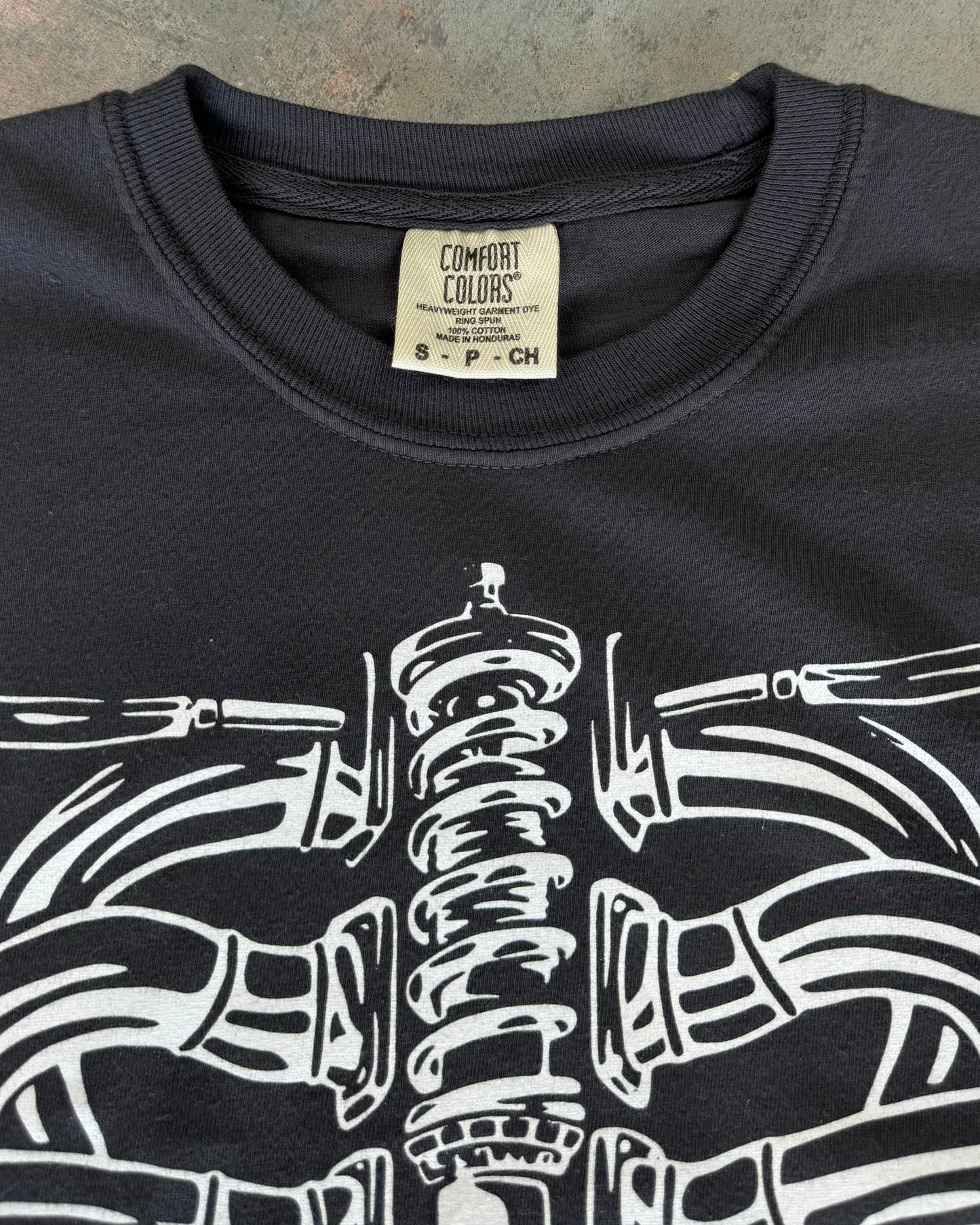 Black T-shirt featuring a hand-drawn design of a human ribcage made from various car parts. The design includes intricate details with text 'Destroying Dailys' incorporated into the ribs, appealing to car enthusiasts. Perfect for car fans, this T-shirt is made from soft 100% cotton, pre-shrunk, and garment dyed for a comfortable fit. Ideal for showcasing your passion for cars with a unique, artistic twist. With comfort colors tag