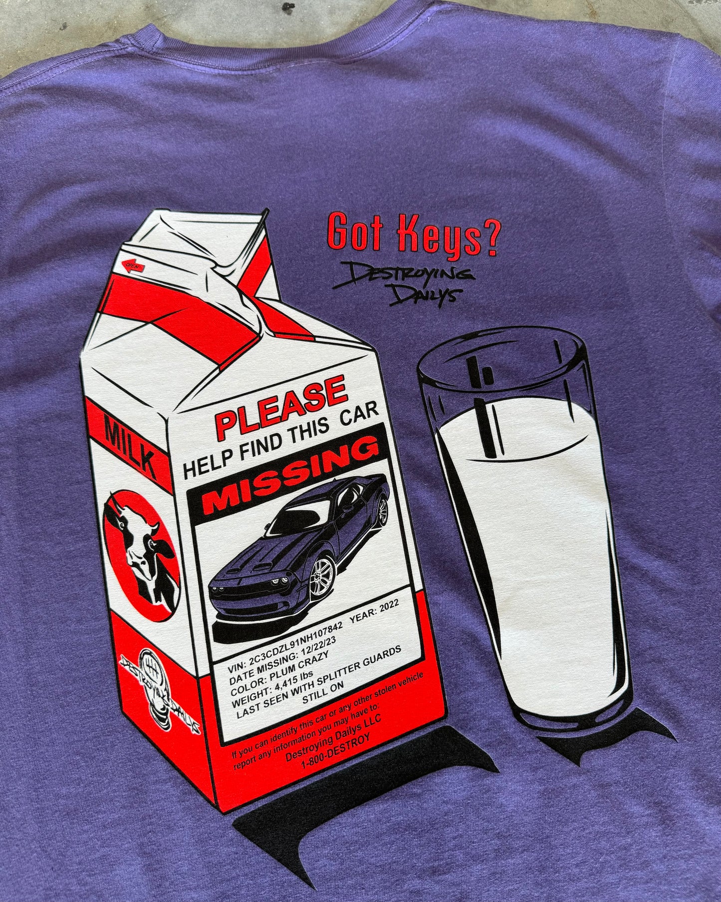 Purple hand-drawn dodge challenger hellcat T-shirt featuring a unique design of a missing Dodge Challenger Hellcat on a milk carton with a glass of milk. Text includes 'Got Keys?' and 'Destroying Days.' Made from soft 100% cotton, pre-shrunk, and garment dyed. Perfect for car enthusiasts and Dodge Challenger Hellcat fans. Comfortable casual wear with a creative, artistic touch. close up back of t shirt