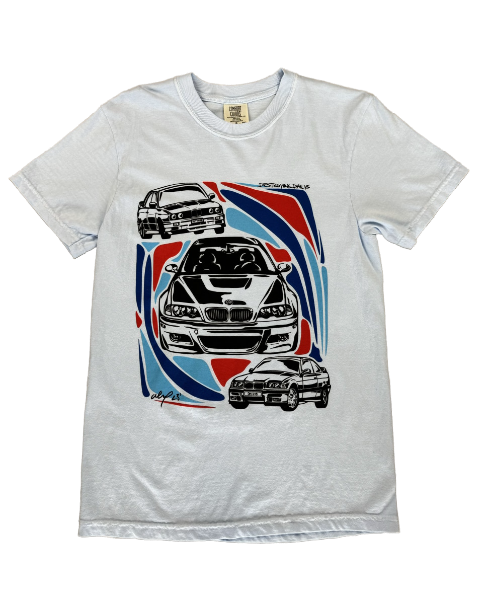 Light blue 100% cotton t-shirt featuring hand-drawn BMW E30, E36, and E46 designs with red, blue, and black accents, ideal for car enthusiasts.